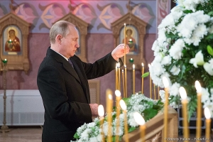 Президент России Владимир Путин ставит свечи в храме преподобного Сергия Радонежского 8 декабря 2014 года. Фото Дмитрия Фуфаева
