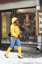 Иностранцы.Женщина идет по городу в желтых сапогах, мужчина на витрине едет на велосипеде. Каждому свое. Фотограф Дмитрий Фуфаев.
