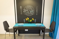 Кухня в современном стиле. Зона столовой. Белая стена, черный стол, черные стулья, черная доска для мела, голубые акценты. Фотограф Дмитрий Фуфаев.